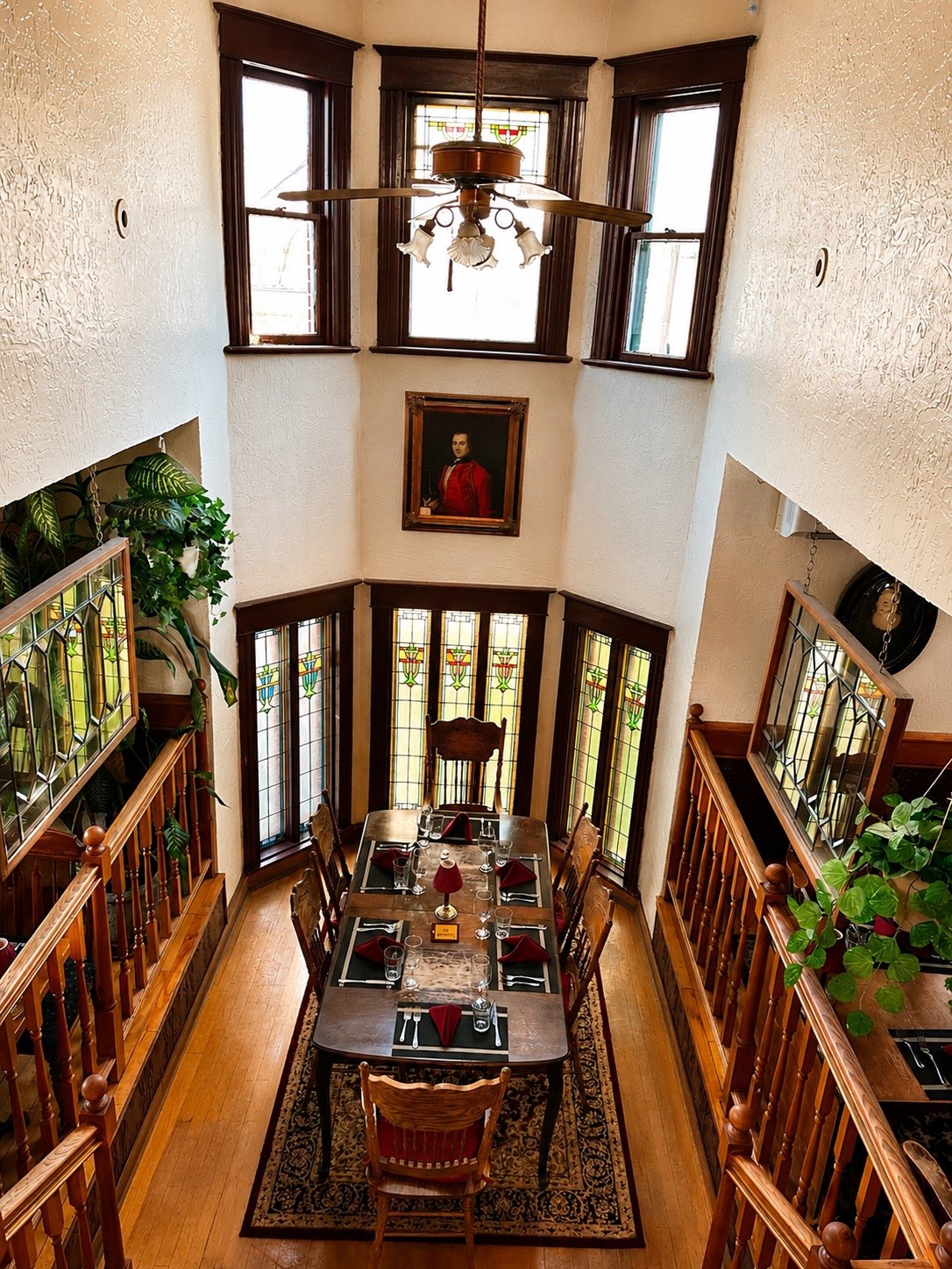 The double-storey Bay Window room with stained glass windows, seen from the staircase above
