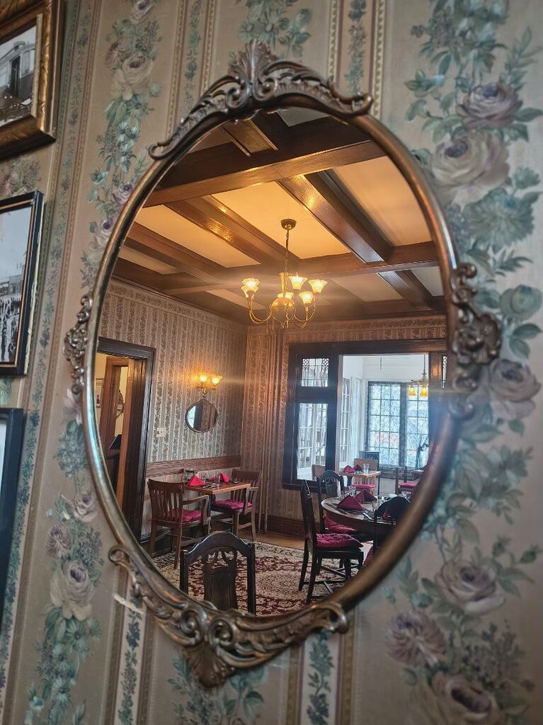 Victorian dining room reflected in an antique oval mirror